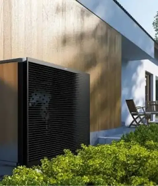 Warmtepomp buiten bij een houten gevel
